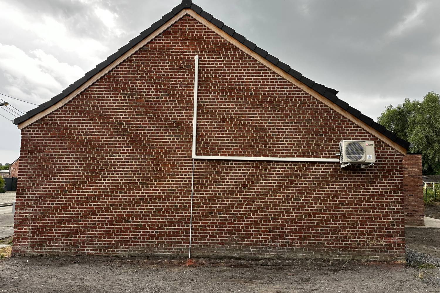 Installation d'une unité extérieure sur mur brique — habitation privée Wallonie